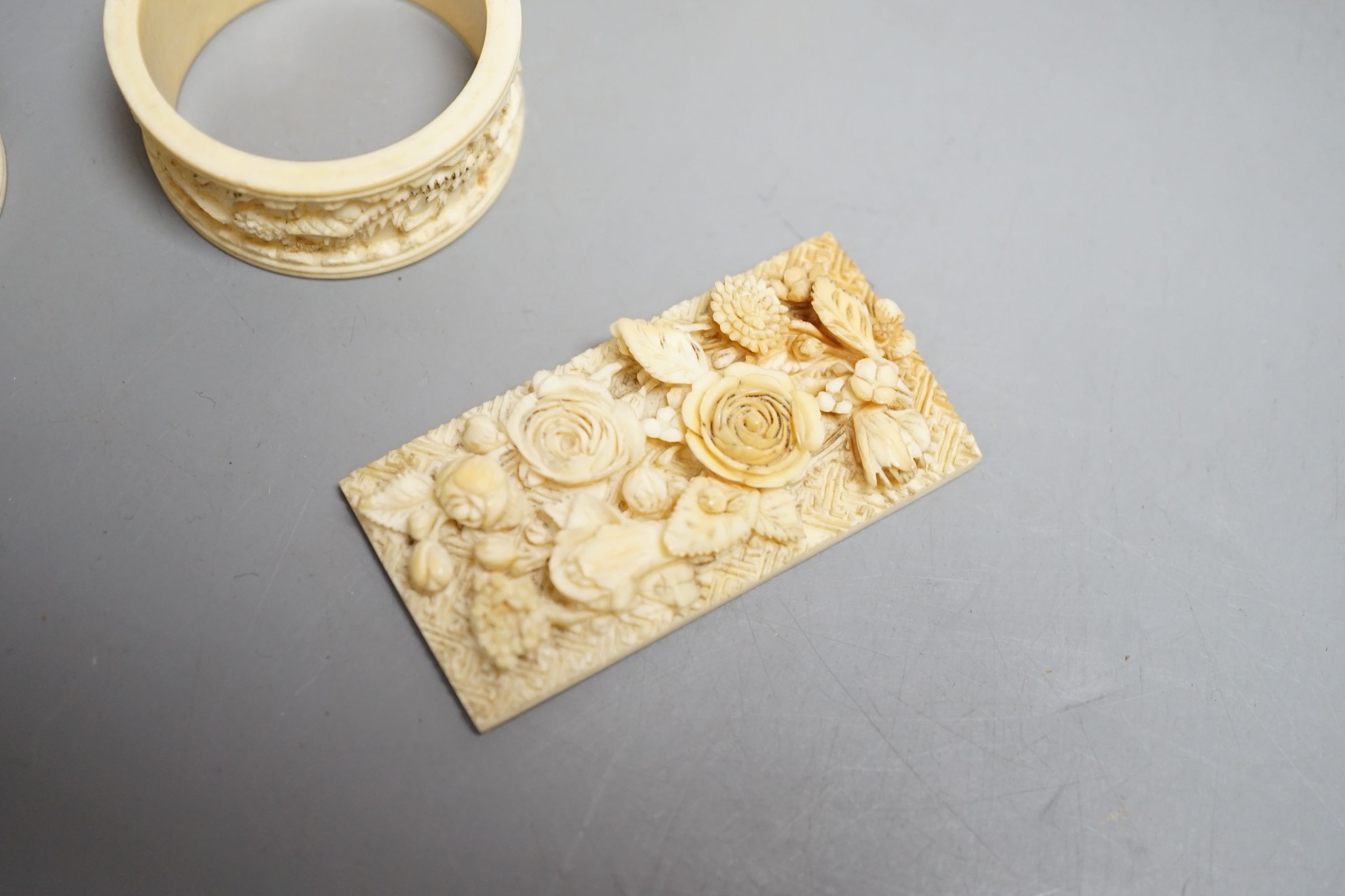 A Chinese ivory figure of Guanyin, a pair of ivory chess pieces, two Cantonese napkin rings and a Cantonese ivory plaque with flowers, 19th/early 20th century , tallest chess piece 8.5 cms high.